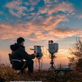 秋色之空技术顾问方云峰的户外工作照，正在野外测试气象仪器，背景是晴朗的秋日天空，专业感十足